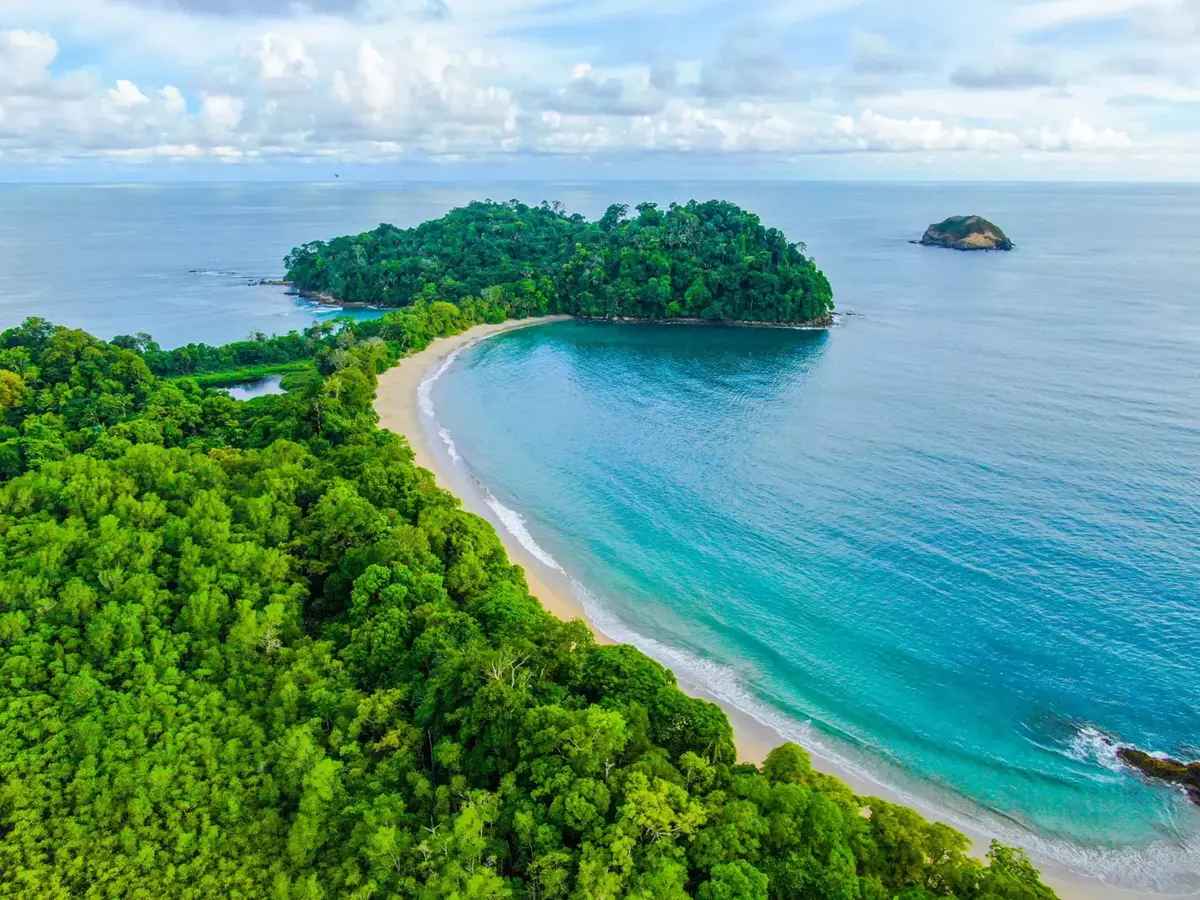 Playa de arena blanca y aguas turquesas bordeada por selva tropical en el Parque Nacional Manuel Antonio, Costa Rica.