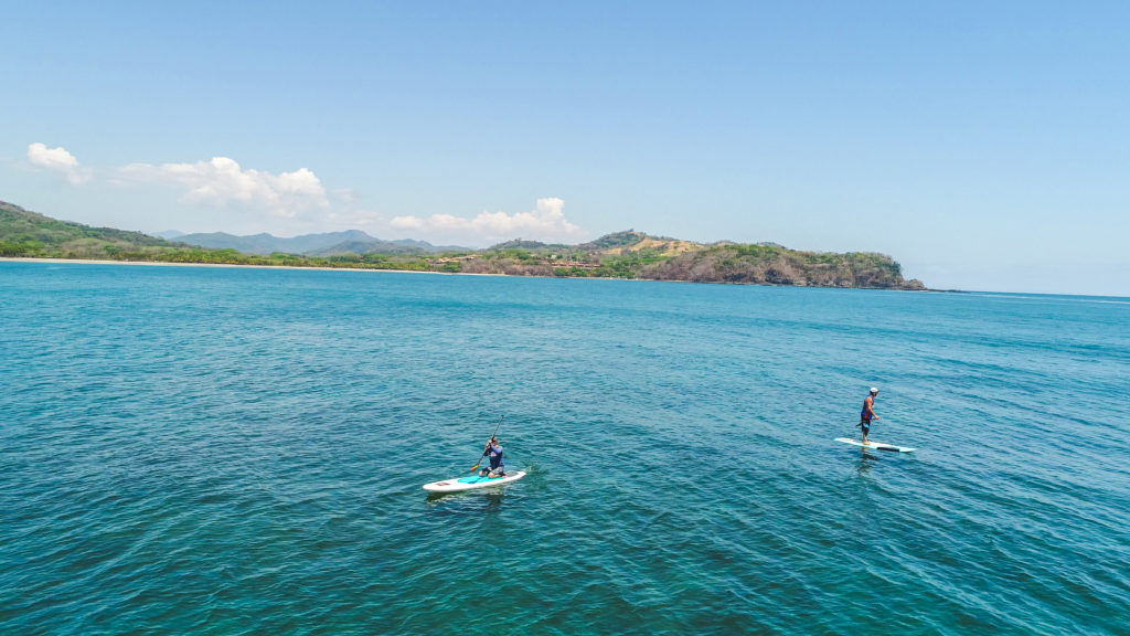 Persona practicando paddle board en aguas tranquilas